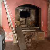 Torniamo nella corte e, tramite una piccola porta, giungiamo nella vecchia cucina dove si trova un grande camino forato al centro